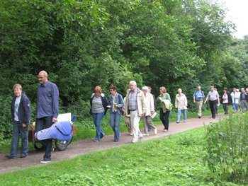 Ökumenische Abendwanderung Eine Gruppe von Männern und Frauen bei einer Abendwanderung auf einem Feldweg am Waldrand